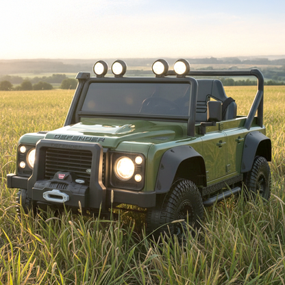 Green off-road vehicle in a grassy field with a clear sky